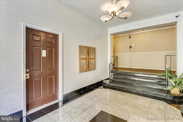 a view of kitchen and empty room with wooden floor