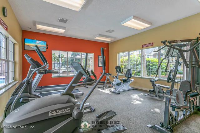 a room with gym equipment and large windows