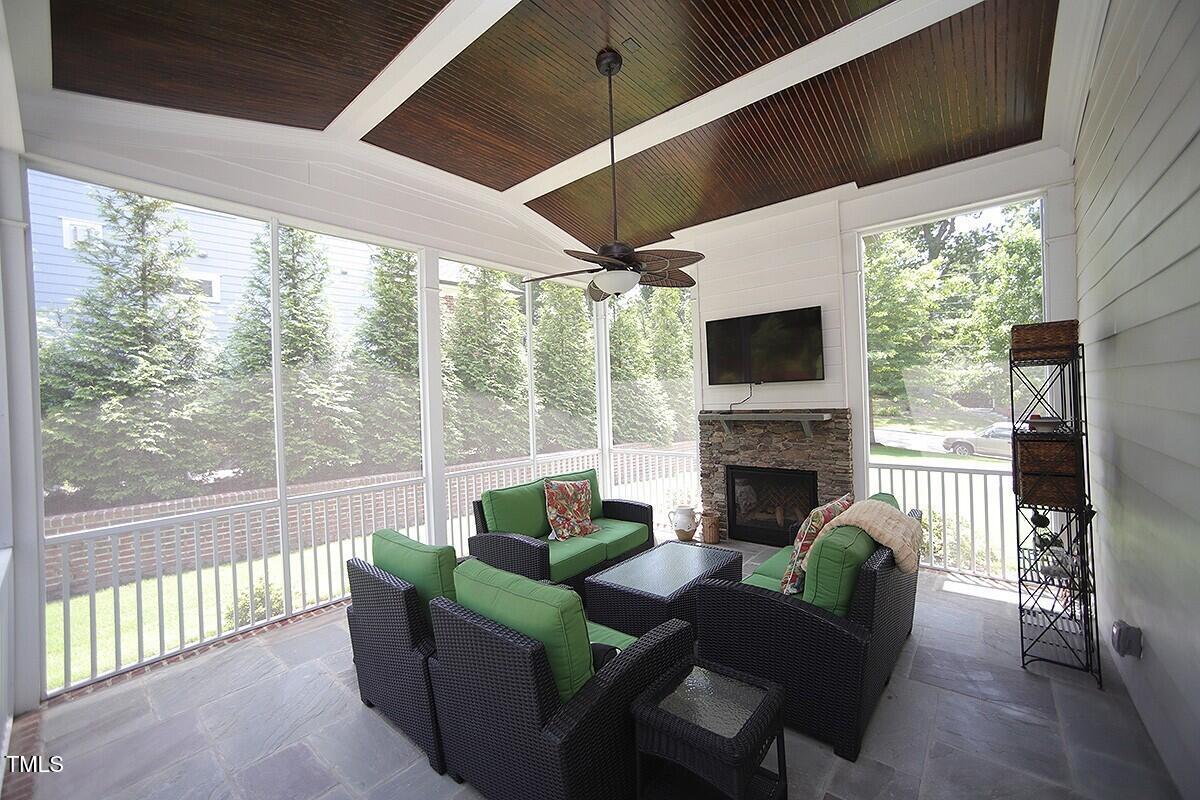 615 Sampson Street Raleigh, NC 27609 - Photo 23 of 26 a living room with furniture a fireplace and a floor to ceiling window