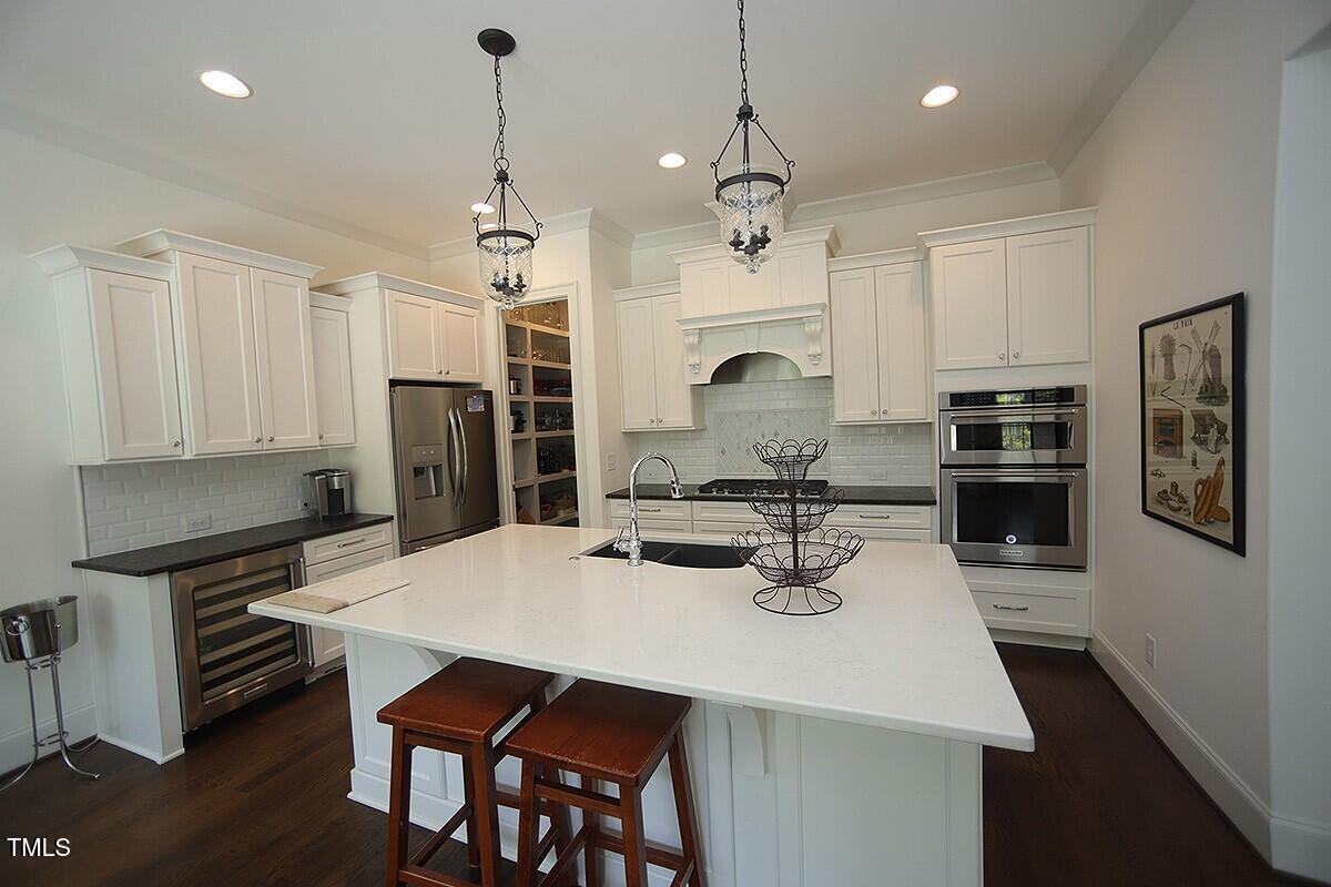 615 Sampson Street Raleigh, NC 27609 - Photo 8 of 26 a kitchen with stainless steel appliances a dining table and chairs