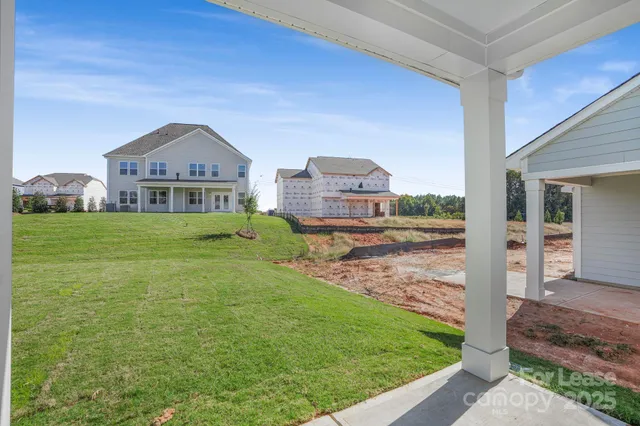 a view of a big house with a big yard and large tree