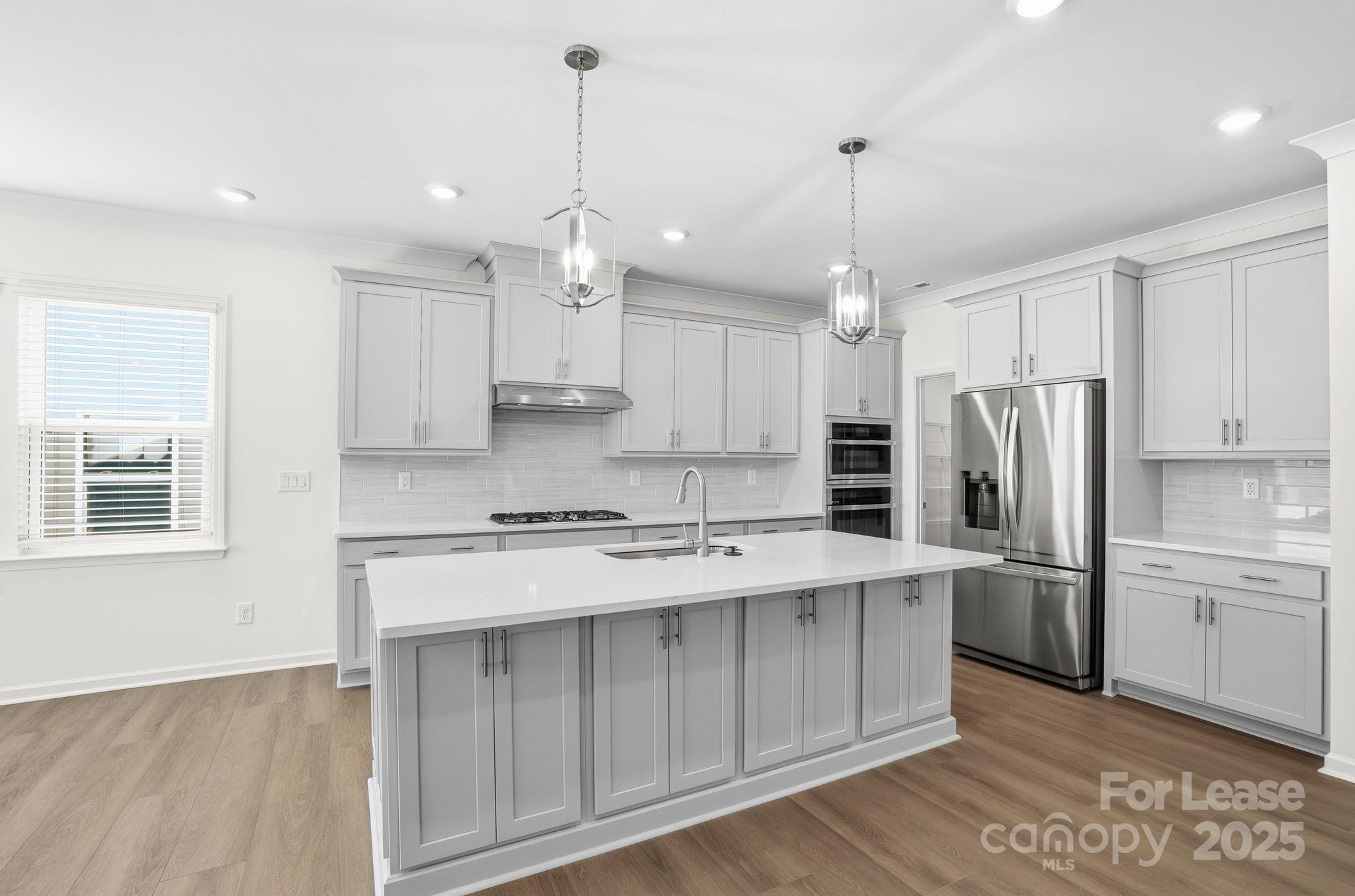 10205 Whitaker Pointe Drive Huntersville, NC 28078 - Photo 15 of 48 a kitchen with stainless steel appliances granite countertop a refrigerator a sink dishwasher a stove and white cabinets with wooden floor