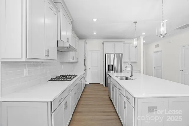a kitchen with kitchen island stainless steel appliances a sink a refrigerator and a stove