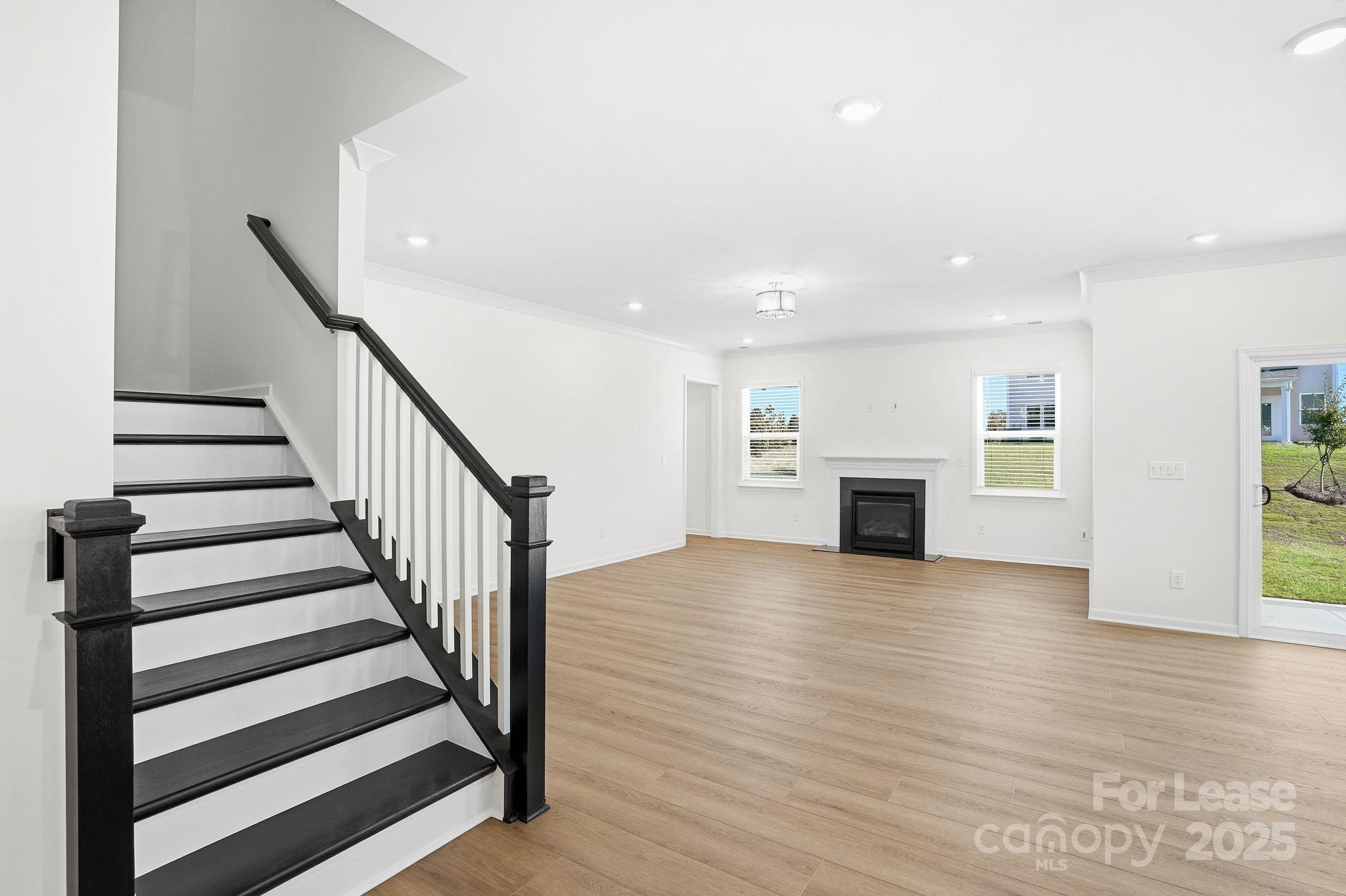 10205 Whitaker Pointe Drive Huntersville, NC 28078 - Photo 23 of 48 an empty room with wooden floor and fireplace