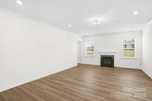 a view of empty room with wooden floor and fireplace