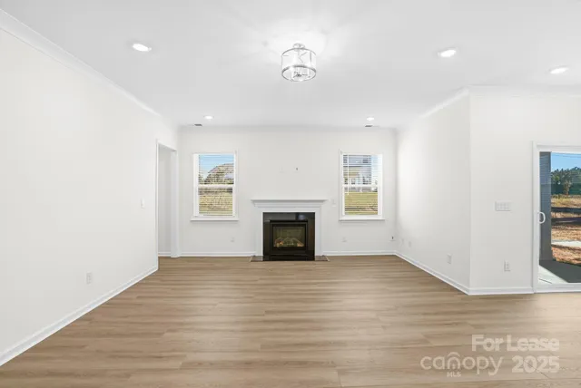 a view of a livingroom with wooden floor and a fireplace