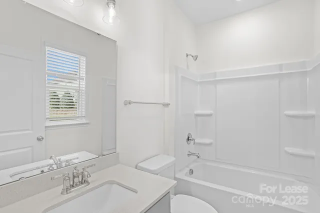 a bathroom with a bathtub shower sink vanity and a toilet