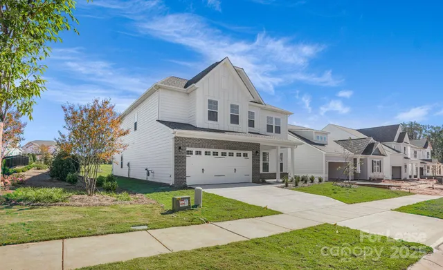 a view of house with garden and tall tress