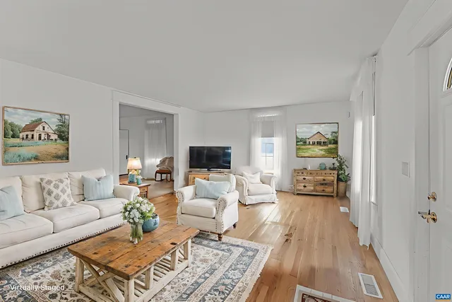 a bed sitting in a spacious bedroom next to a large window