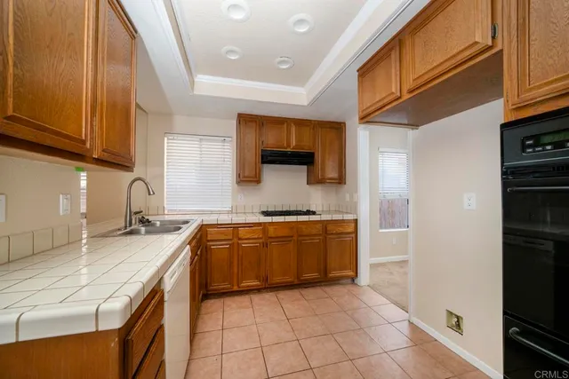 a kitchen with stainless steel appliances granite countertop a sink and a stove
