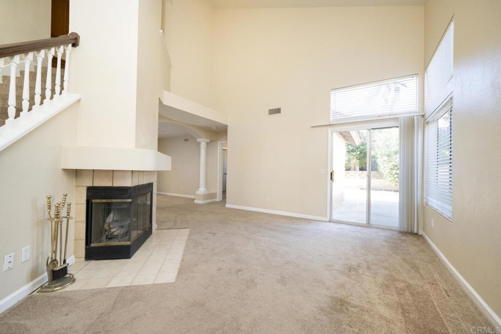 1744 Via Allena Oceanside, CA 92056 - Photo 5 of 36 an empty room with fireplace and windows