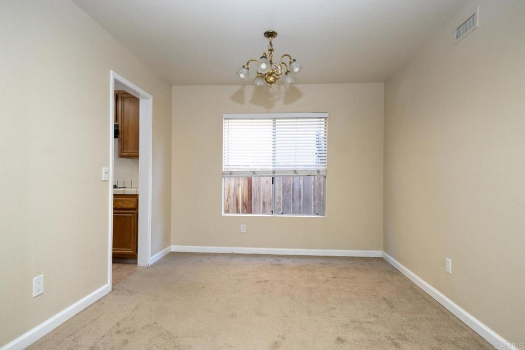 1744 Via Allena Oceanside, CA 92056 - Photo 9 of 36 an empty room with chandelier and windows