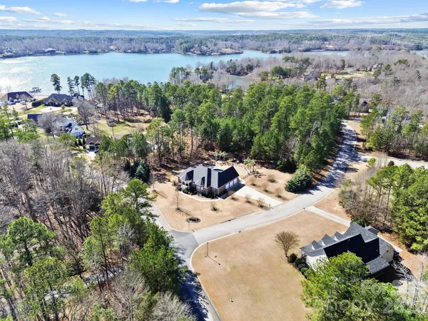 an aerial view of a house with a yard and lake view