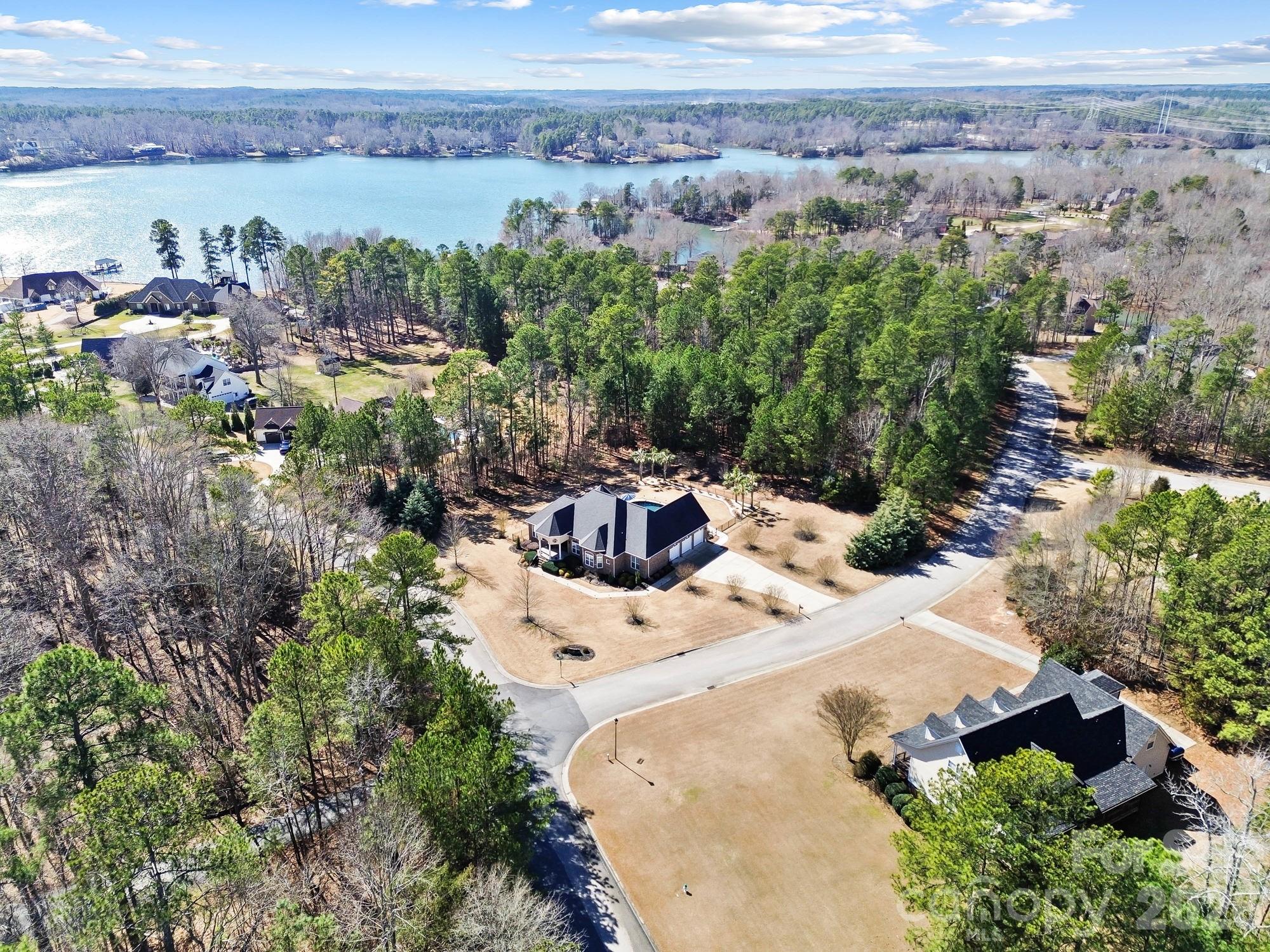 an aerial view of a house with a yard and lake view