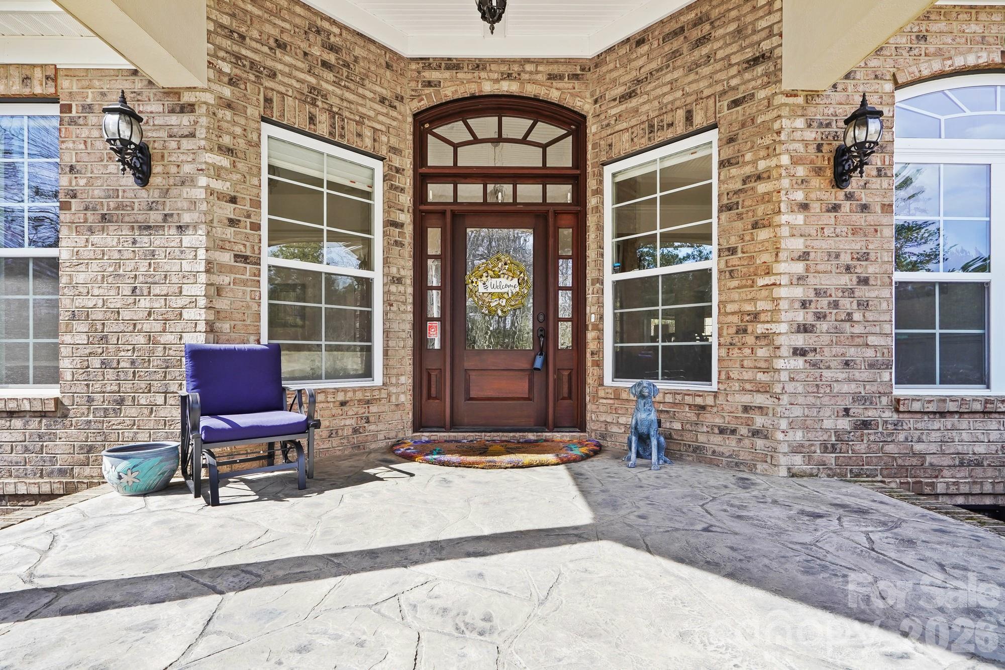 5312 Johnsons Barn Road York, SC 29745 - Photo 7 of 46 a view of a brick house with a chairs and table in a patio