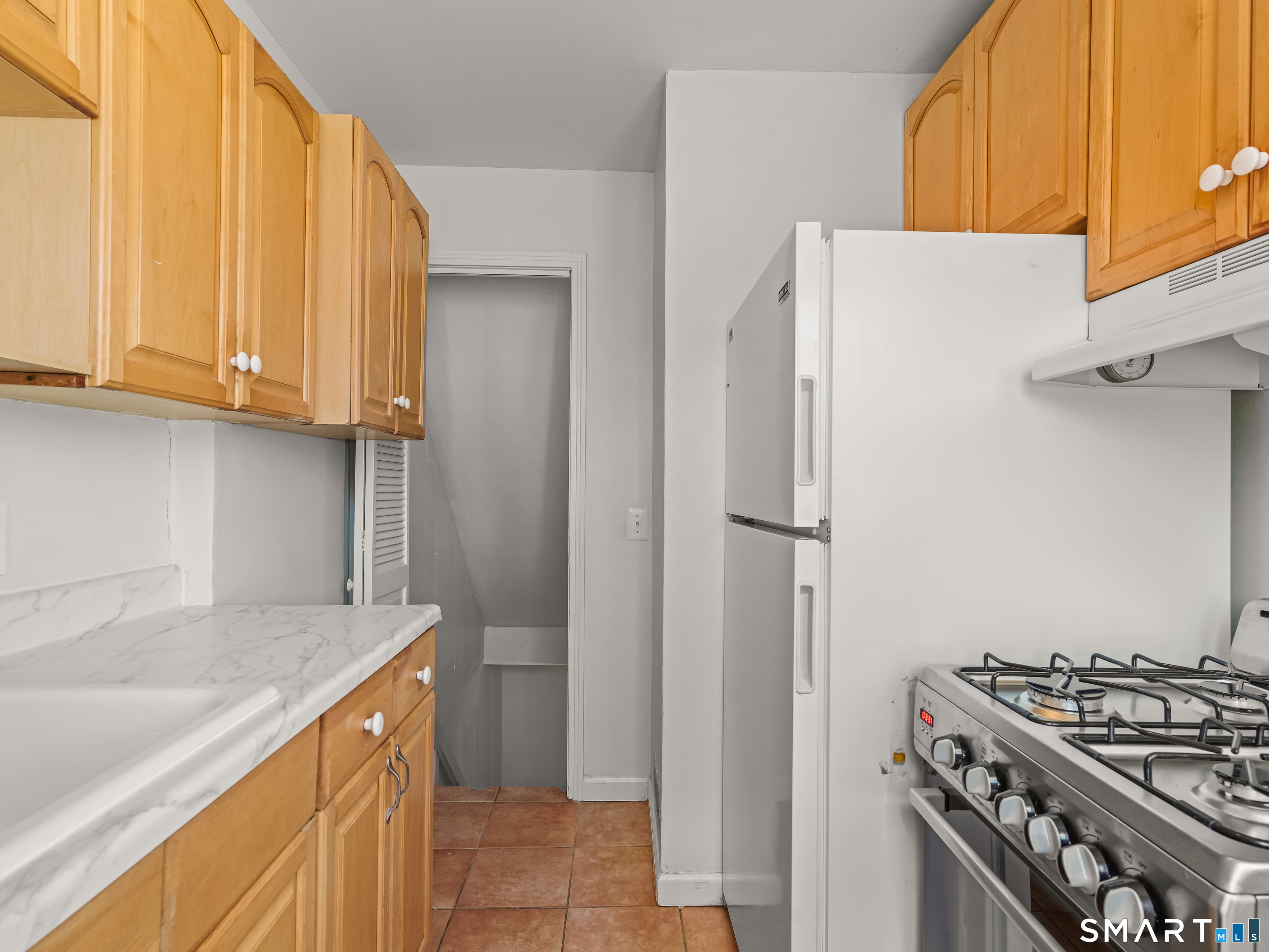 214 Sylvan Knoll Road, Unit 214 Stamford, CT 06902 - Photo 13 of 30 a kitchen with stainless steel appliances granite countertop a refrigerator and a sink