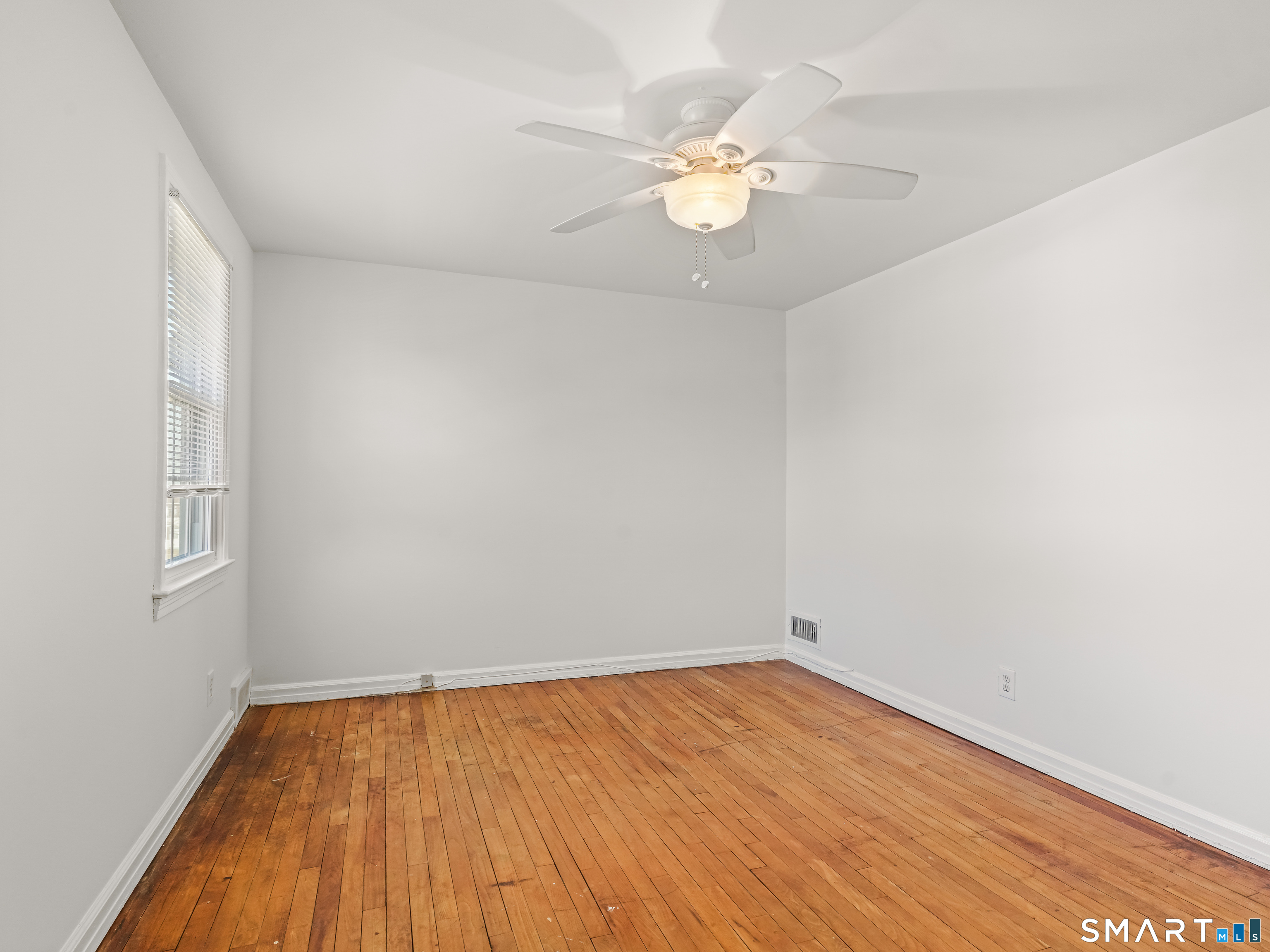 214 Sylvan Knoll Road, Unit 214 Stamford, CT 06902 - Photo 16 of 30 an empty room with wooden floor and fan