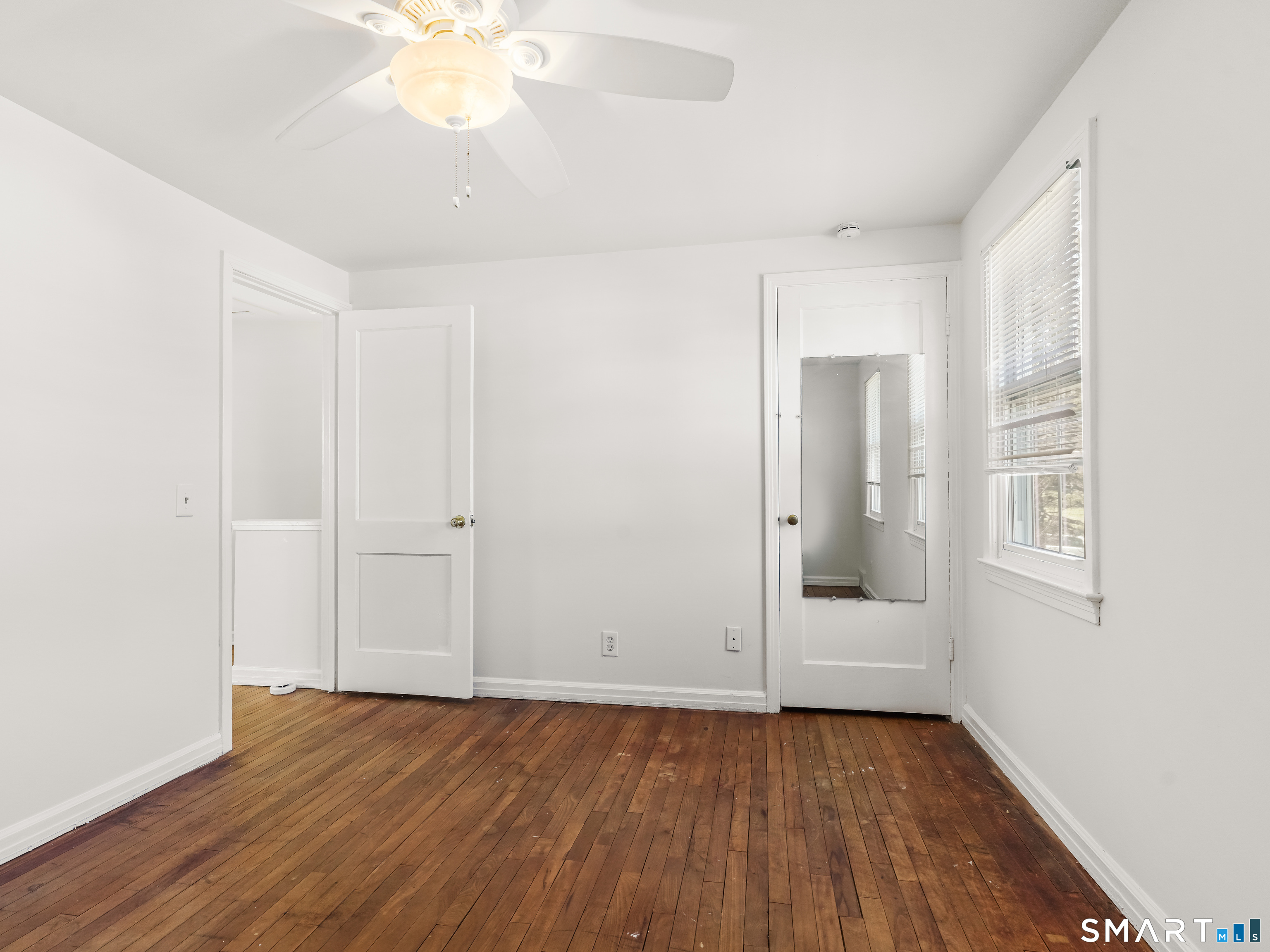 214 Sylvan Knoll Road, Unit 214 Stamford, CT 06902 - Photo 17 of 30 wooden floor in an empty room with a window