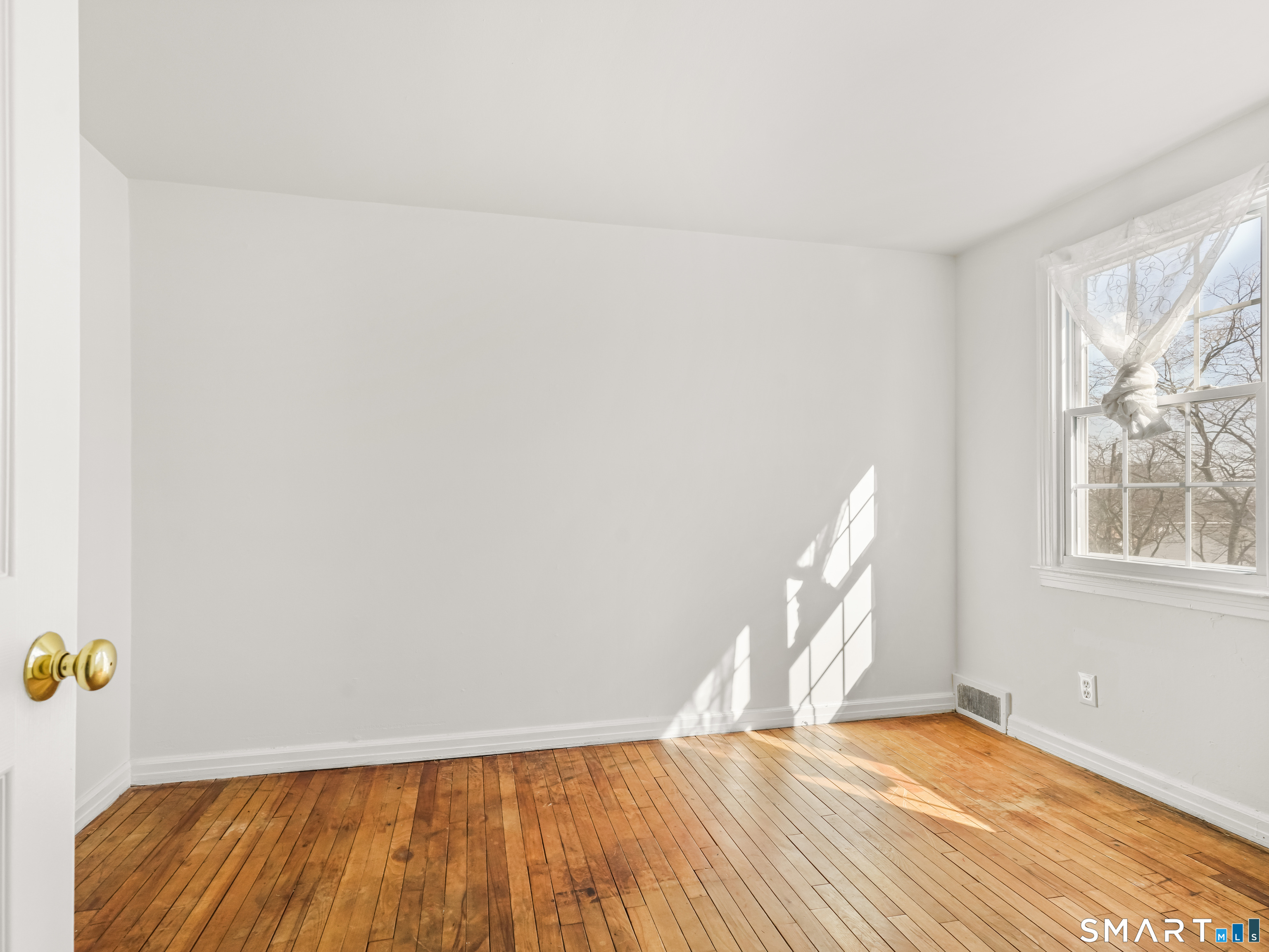 214 Sylvan Knoll Road, Unit 214 Stamford, CT 06902 - Photo 18 of 30 a view of an empty room with wooden floor and a window