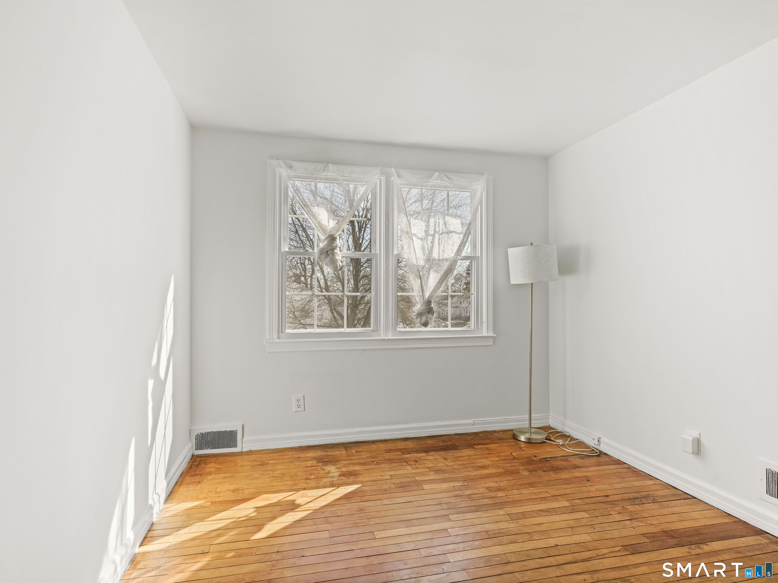 214 Sylvan Knoll Road, Unit 214 Stamford, CT 06902 - Photo 19 of 30 a view of an empty room with wooden floor and a window
