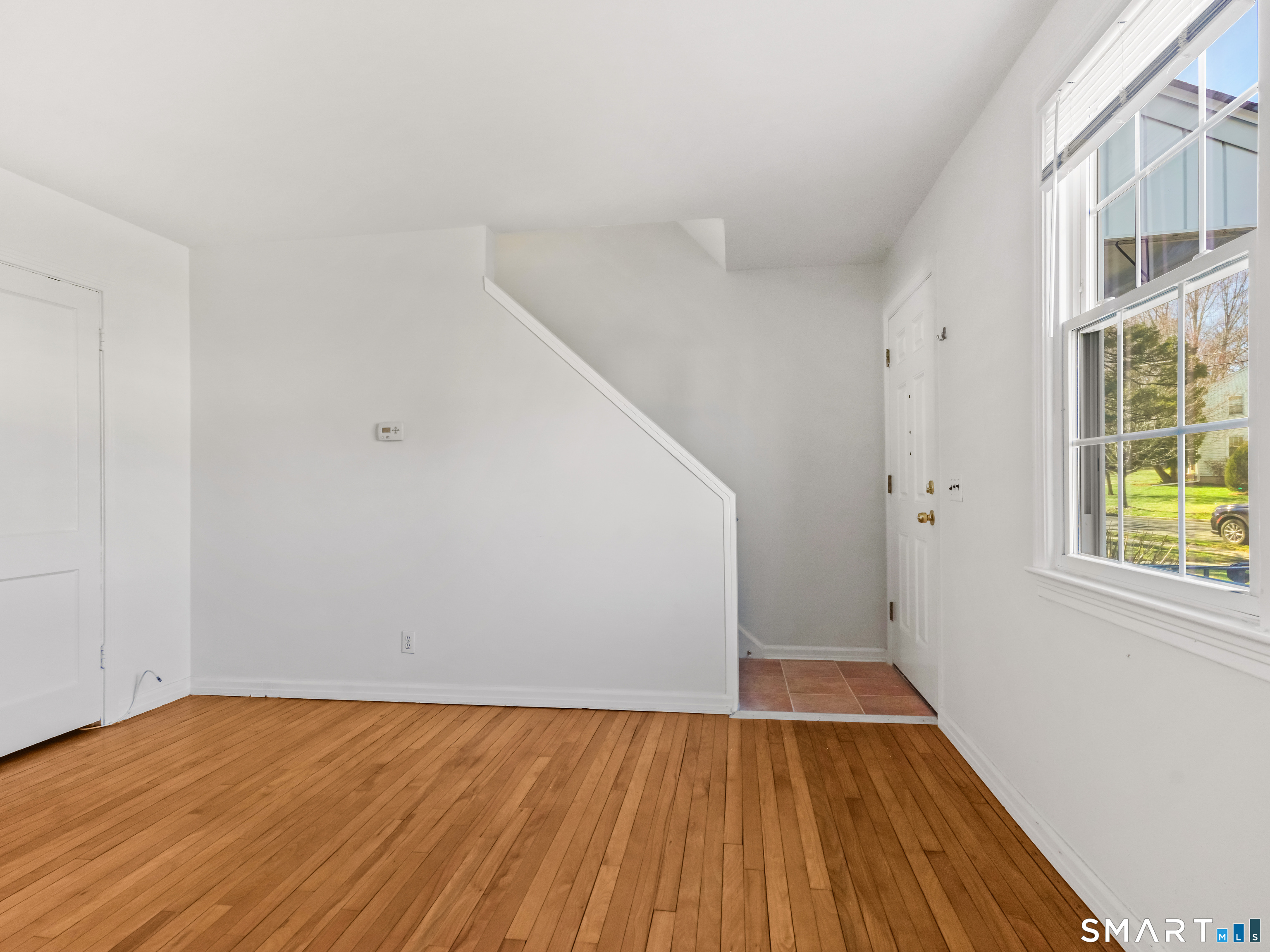 214 Sylvan Knoll Road, Unit 214 Stamford, CT 06902 - Photo 5 of 30 a view of an empty room with wooden floor and a window