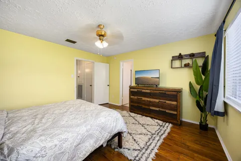 a bedroom with a bed and wooden floor