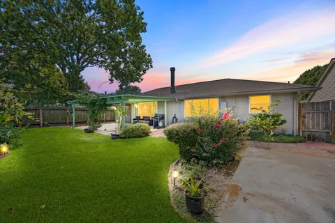 a view of a backyard with table and chairs under an umbrella