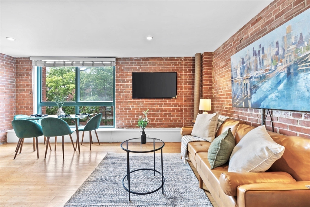 42 8th Street, Unit 1301 Boston, MA 02129 - Photo 2 of 23 a living room with furniture and a flat screen tv