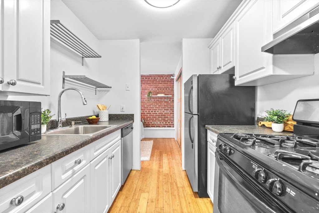 42 8th Street, Unit 1301 Boston, MA 02129 - Photo 6 of 23 a kitchen with stainless steel appliances granite countertop a sink stove and refrigerator