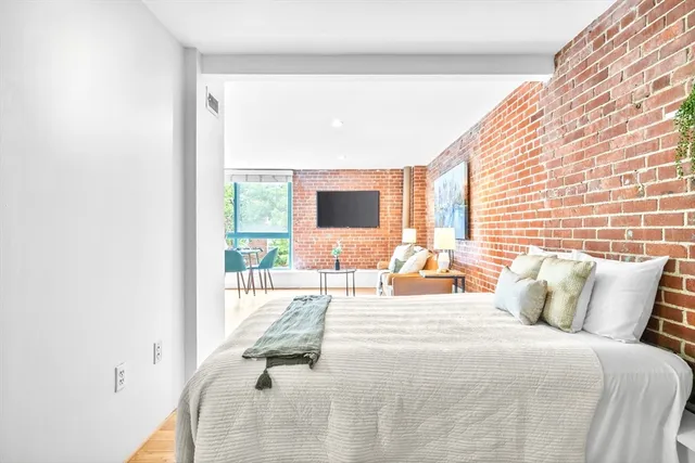 a bedroom with a bed and large window