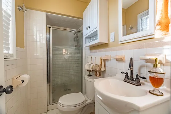 a bathroom with a sink a toilet and shower