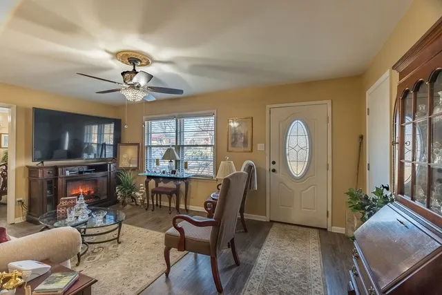 a living room with furniture a flat screen tv and a window
