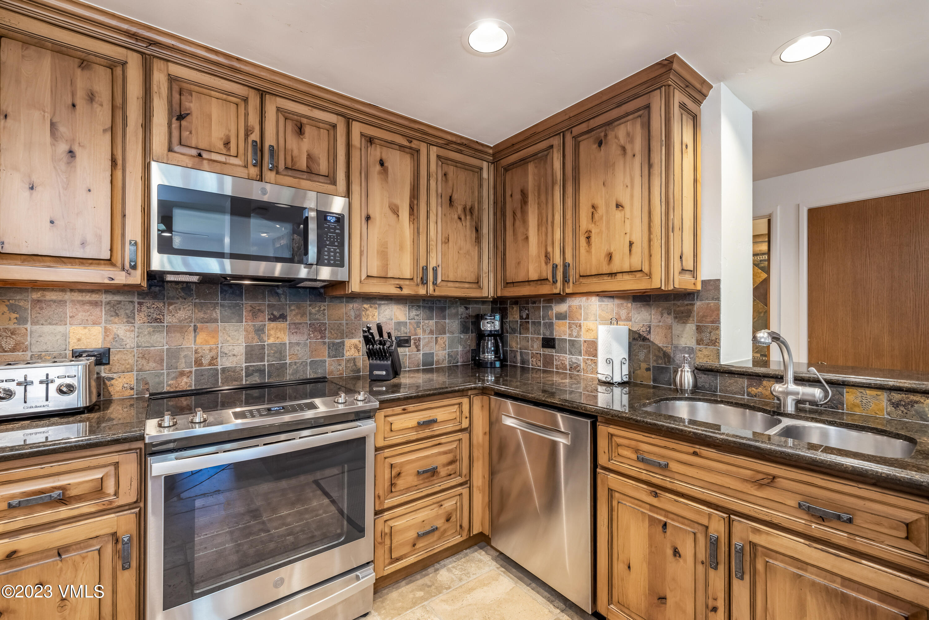 120 Offerson Road, Unit D260 Beaver Creek, CO 81620 - Photo 11 of 41 a kitchen with stainless steel appliances granite countertop a sink stove and microwave