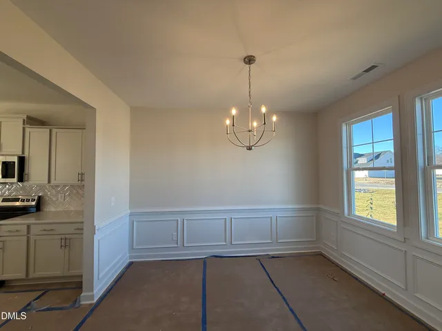 a view of a livingroom with a chandelier fan and windows
