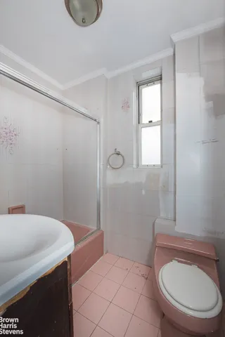 an empty room with wooden floor ceiling fan and windows