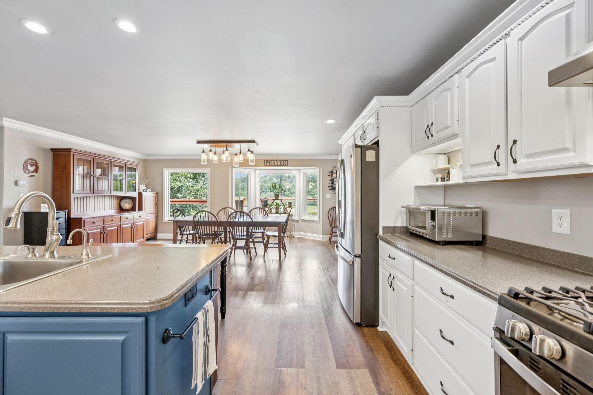 2797 Lewis Road Santa Fe, TN 38482 - Photo 18 of 92 a kitchen with stainless steel appliances granite countertop a stove a sink dishwasher and white cabinets with wooden floor