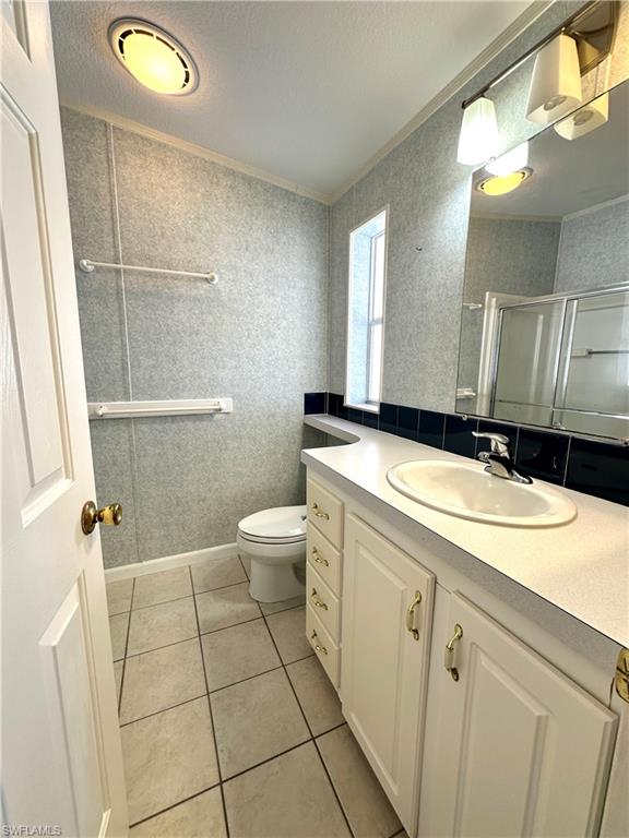 4551 Mayflower Way East Estero, FL 33928 - Photo 18 of 20 a bathroom with a granite countertop sink a toilet and a mirror