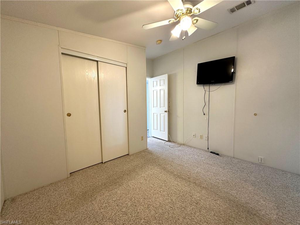 4551 Mayflower Way East Estero, FL 33928 - Photo 19 of 20 en empty room with fan and a flat screen tv