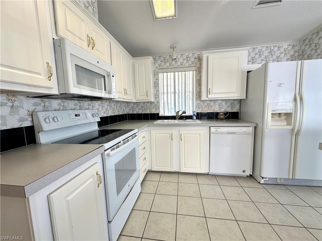 4551 Mayflower Way East Estero, FL 33928 - Photo 10 of 20 a kitchen with stainless steel appliances a white cabinets and a counter space