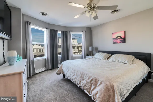 a spacious bedroom with a bed and a chandelier