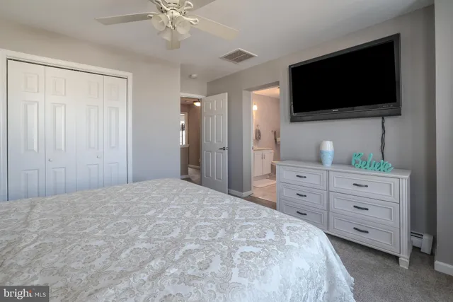 a bedroom with a bed a flat screen tv and a chandelier