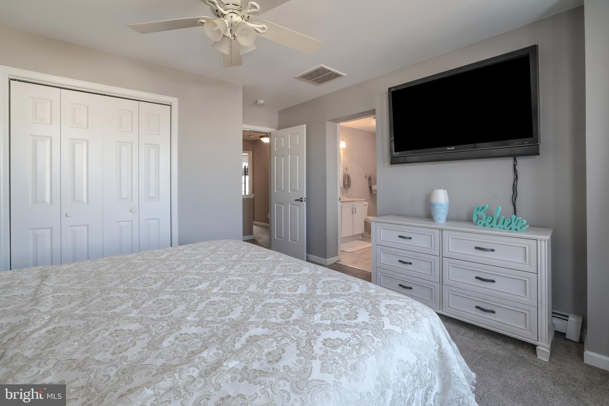 348 Kingfisher Road Tuckerton, NJ 08087 - Photo 18 of 37 a bedroom with a bed a flat screen tv and a chandelier
