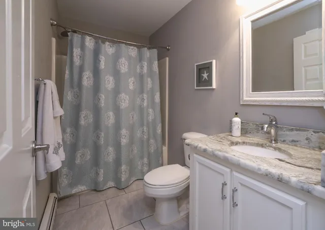 a bathroom with a granite countertop sink toilet and a mirror