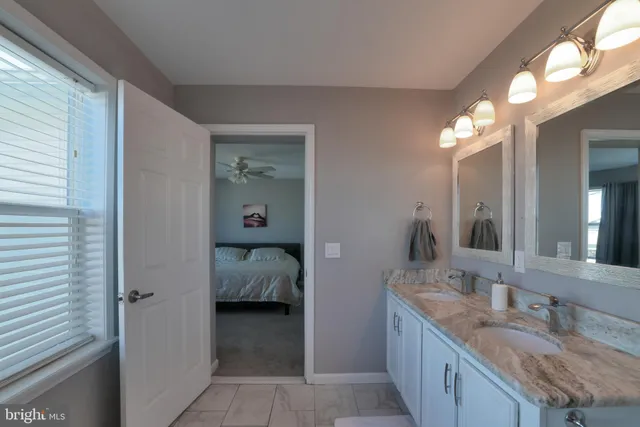 a en suite bathroom with a granite countertop sink and a mirror