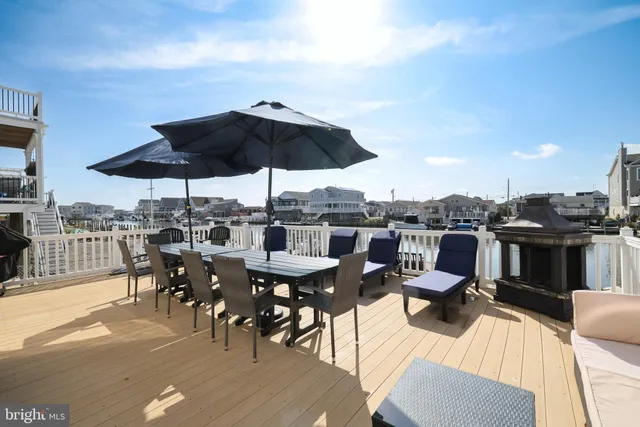 a view of a roof deck with table and chairs under an umbrella