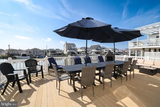 a view of a roof deck with table and chairs under an umbrella