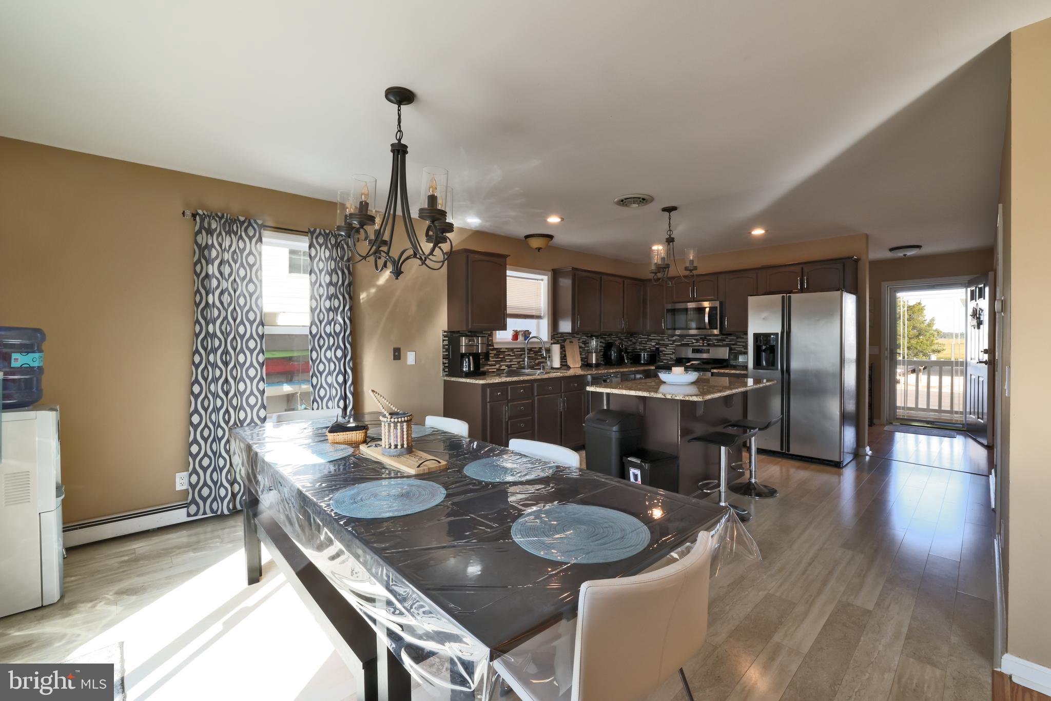348 Kingfisher Road Tuckerton, NJ 08087 - Photo 10 of 37 a view of a dining room and livingroom with furniture wooden floor a chandelier