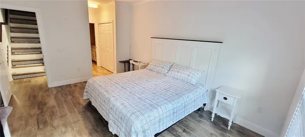 a bedroom with a bed and wooden floor