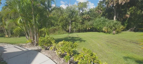 a view of a chair and table in backyard of the house