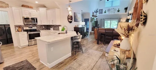 a kitchen with stainless steel appliances kitchen island granite countertop a refrigerator and a stove top oven